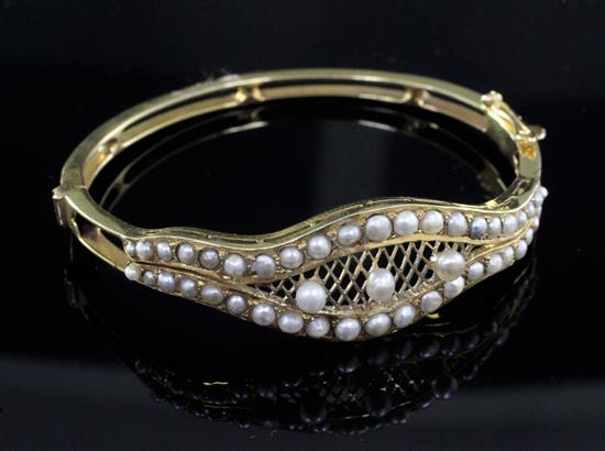 A gold and seed pearl set hinged bangle,